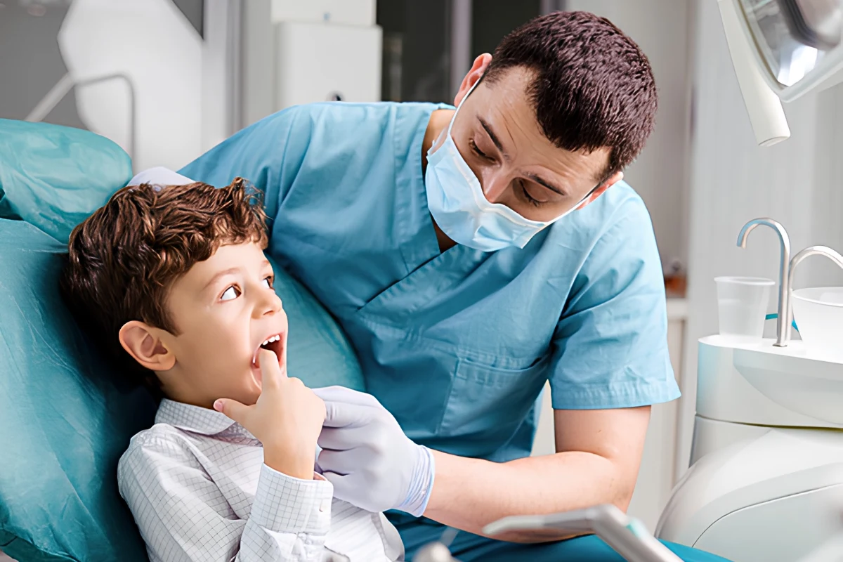 Pediatric dentist examining a child's mouth to diagnose dental problems during a dental visit.