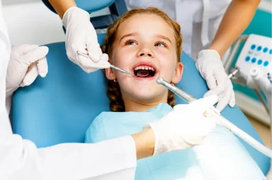 Young child smiling during a comfortable and stress-free pediatric dental checkup.