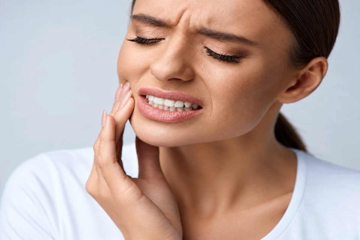 Woman experiencing severe jaw pain and discomfort near the temporomandibular joint
